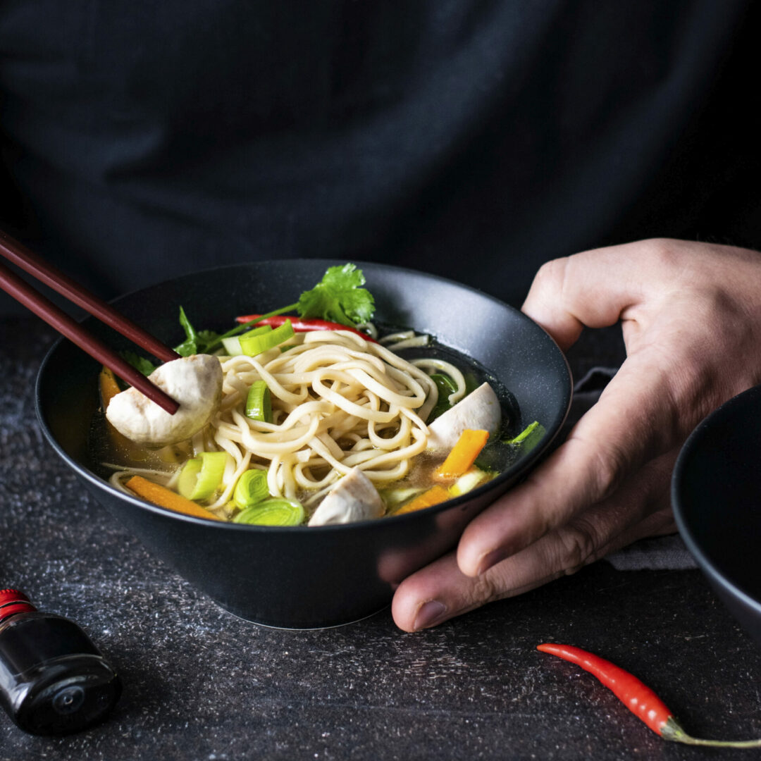Authentic asian noodle soup in a black bowl